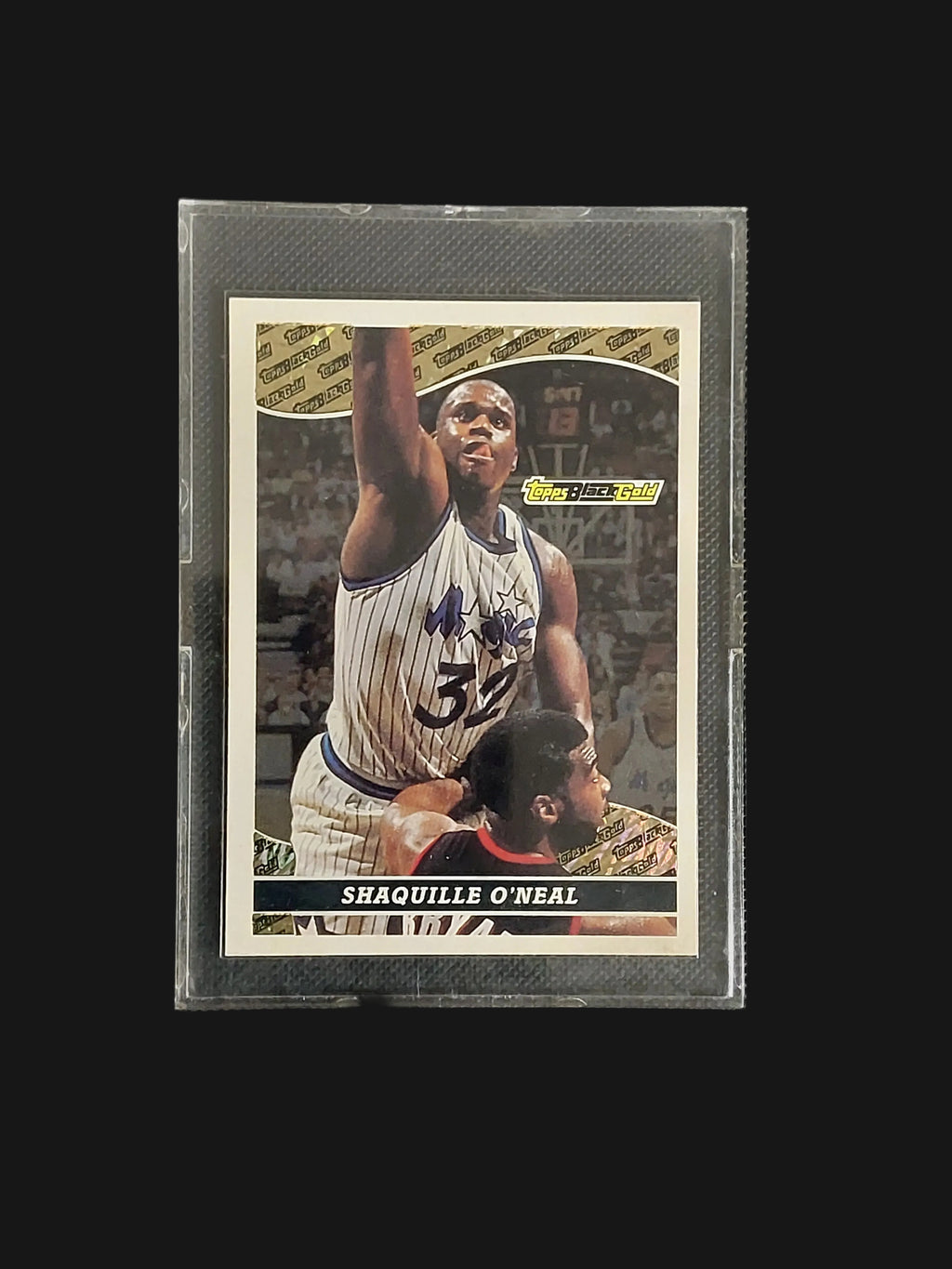Front of 1993-94 Topps Black Gold Shaquille O'Neal #18 featuring Shaq in an Orlando Magic uniform with the black and gold insert design.