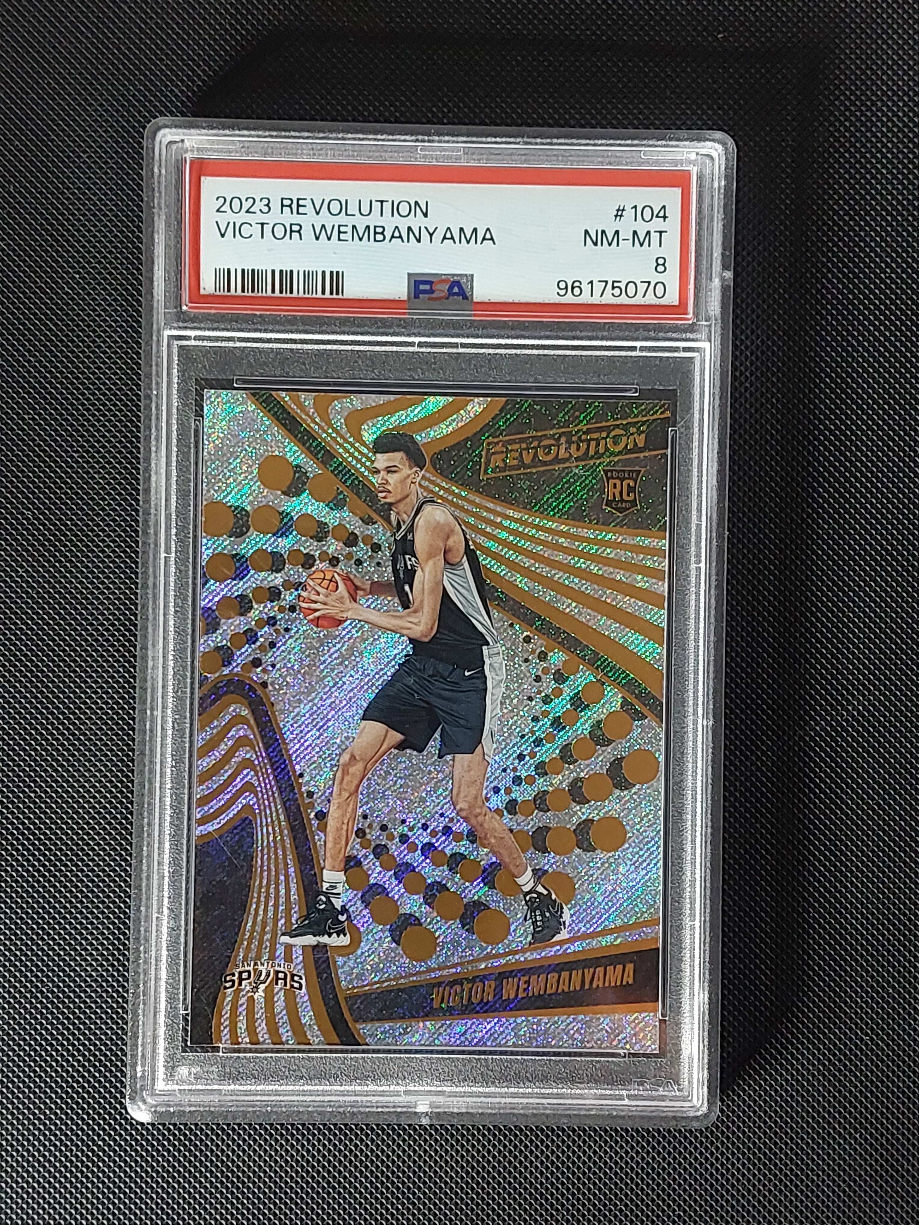 Front of 2023-24 Panini Revolution Victor Wembanyama #104 Sunburst Rookie serial numbered 32/75 and graded PSA NM-MT 8