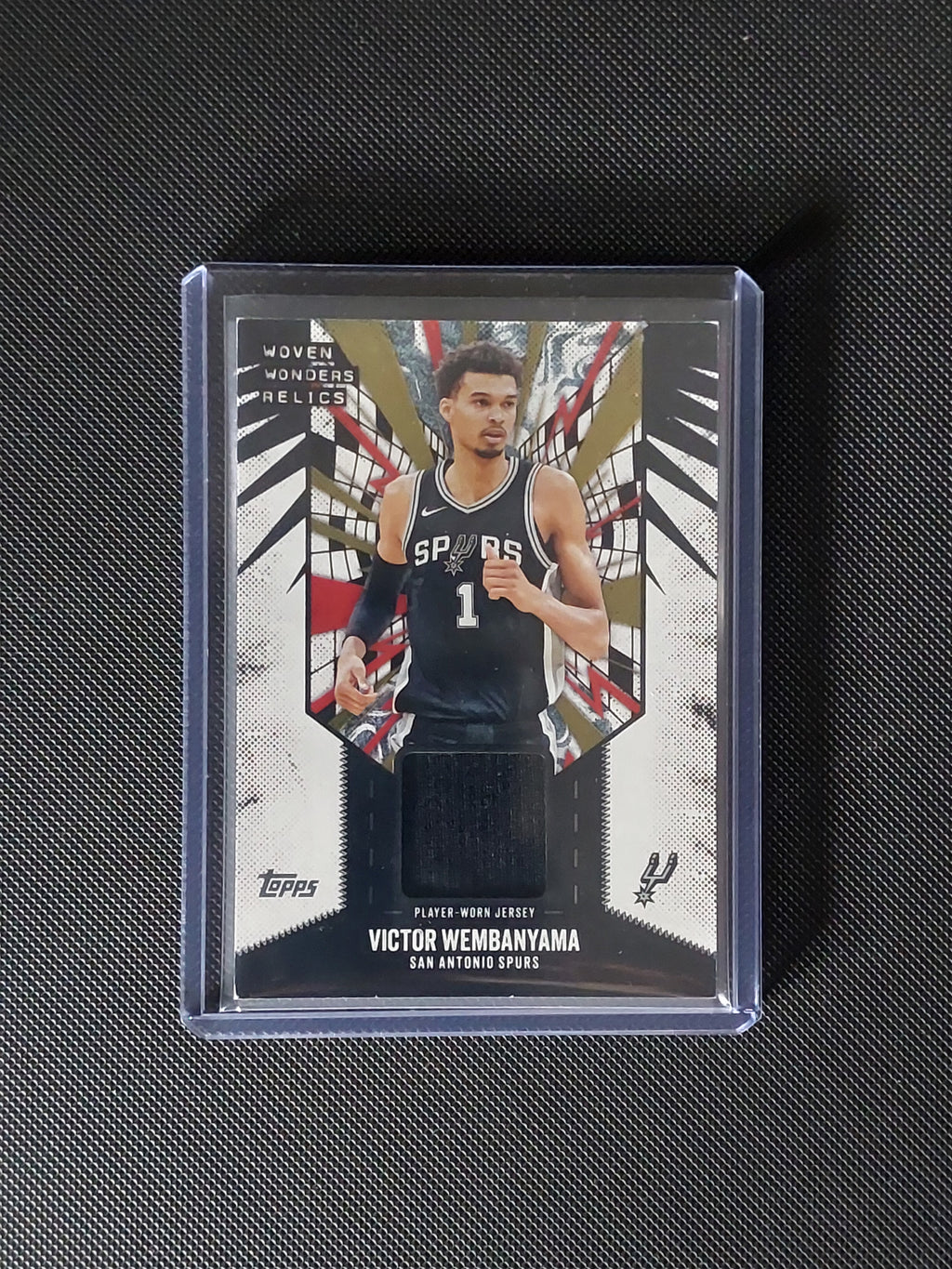 Front of 2025-26 Topps Victor Wembanyama Woven Wonders Relics #WW-VW showing player-worn black jersey swatch